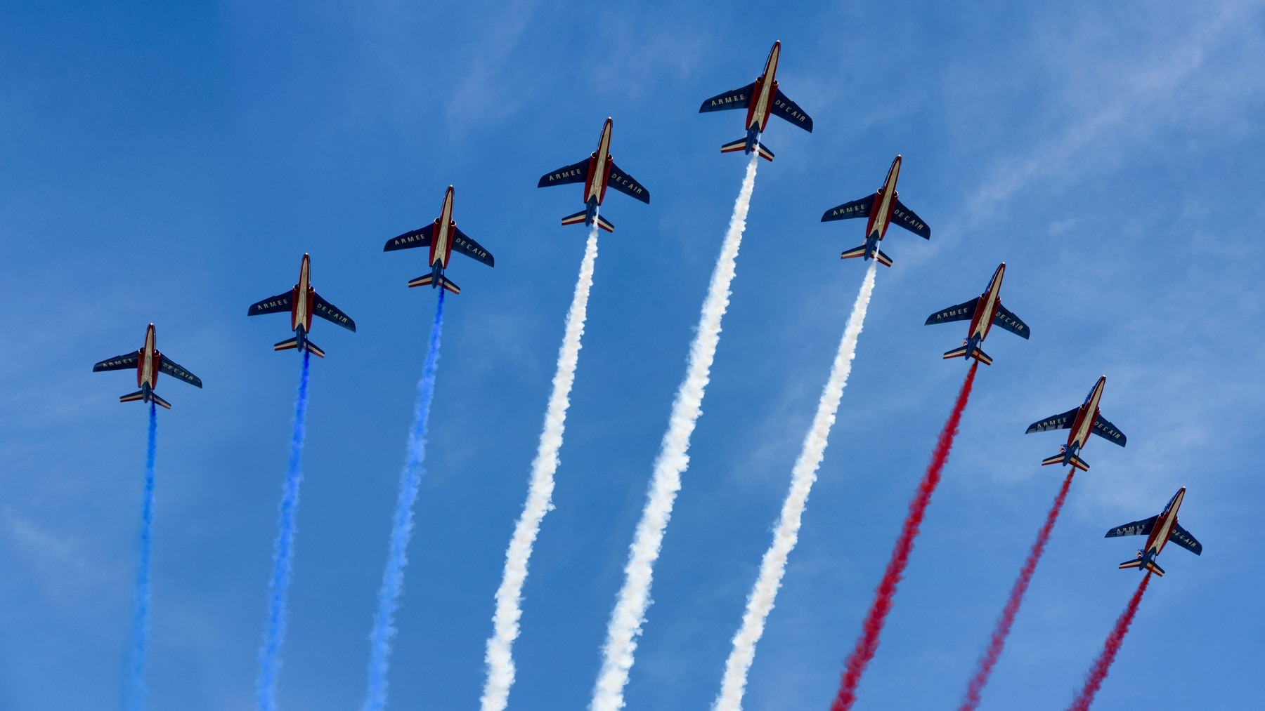 The Patrouille de France flying over Paris trailing blue, white and red smoke during the Bastille Day parade