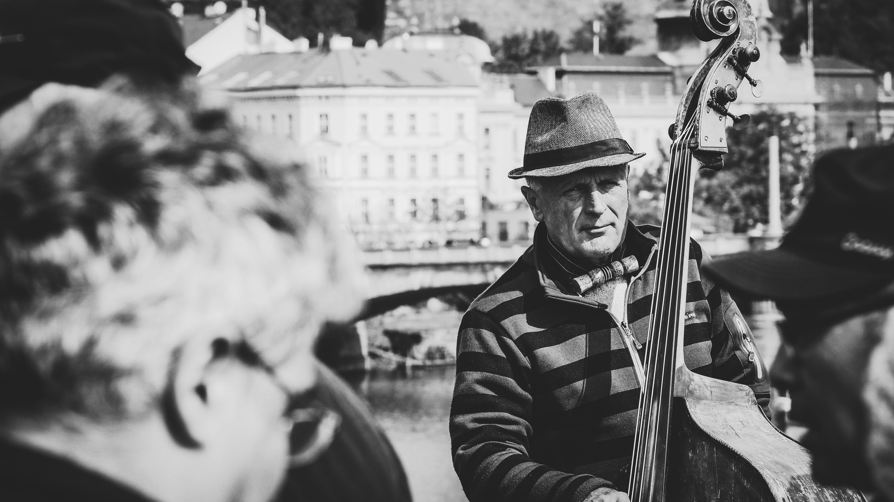 A double bass player performing beside the Vltava river in Prague