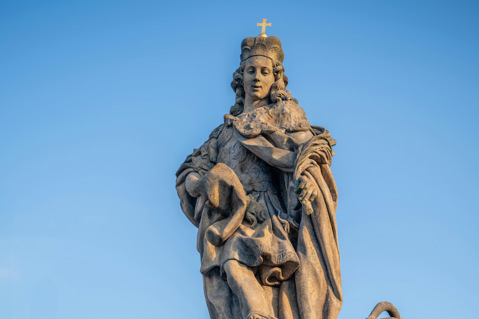 Baroque statues along Charles Bridge during warm evening light