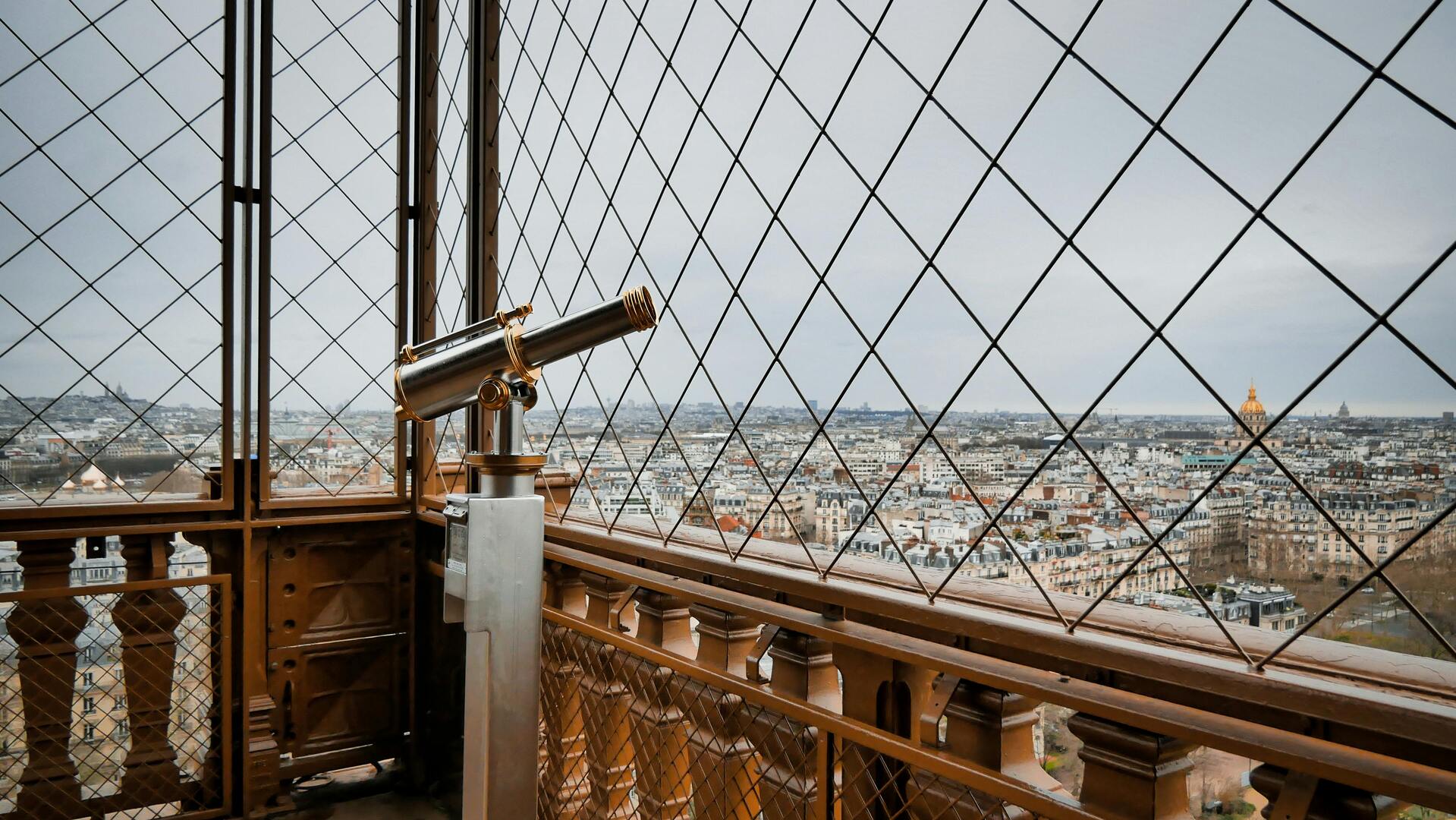 Visitors on the Eiffel Tower first-floor glass deck in mild spring weather