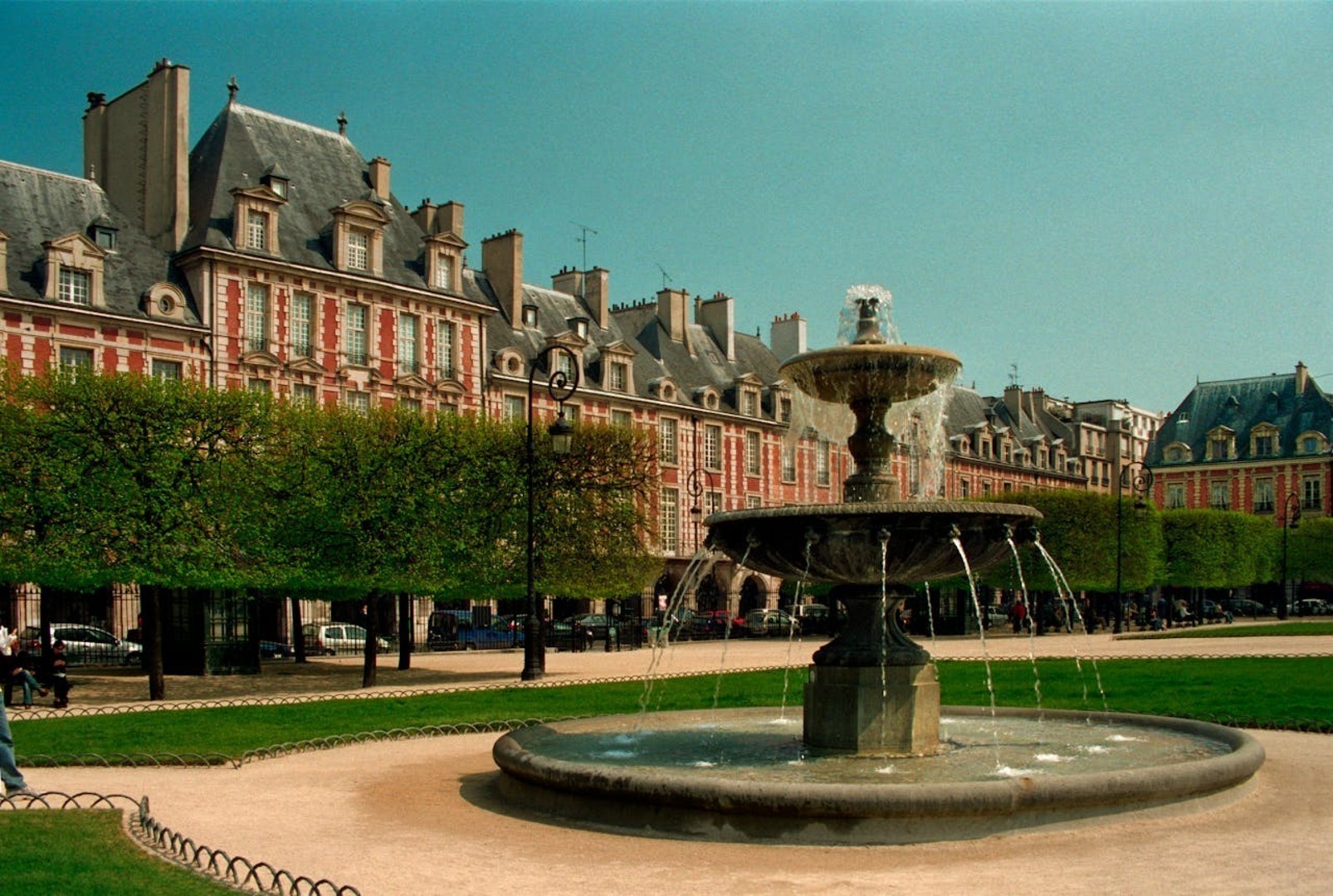 The arcaded galleries of Place des Vosges in Le Marais on a clear spring afternoon