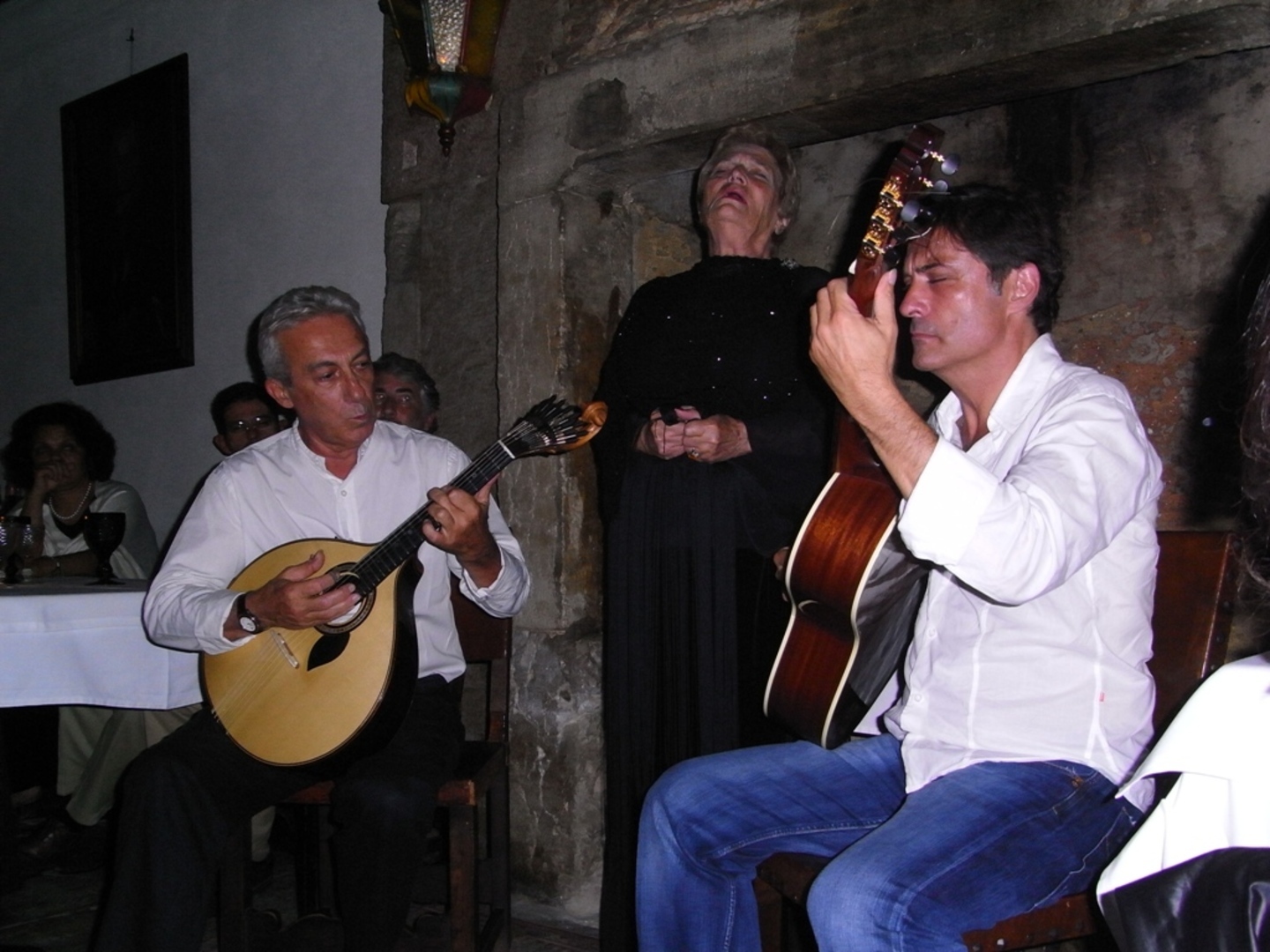 A Portuguese guitar player accompanying a fadista in a traditional Lisbon fado house