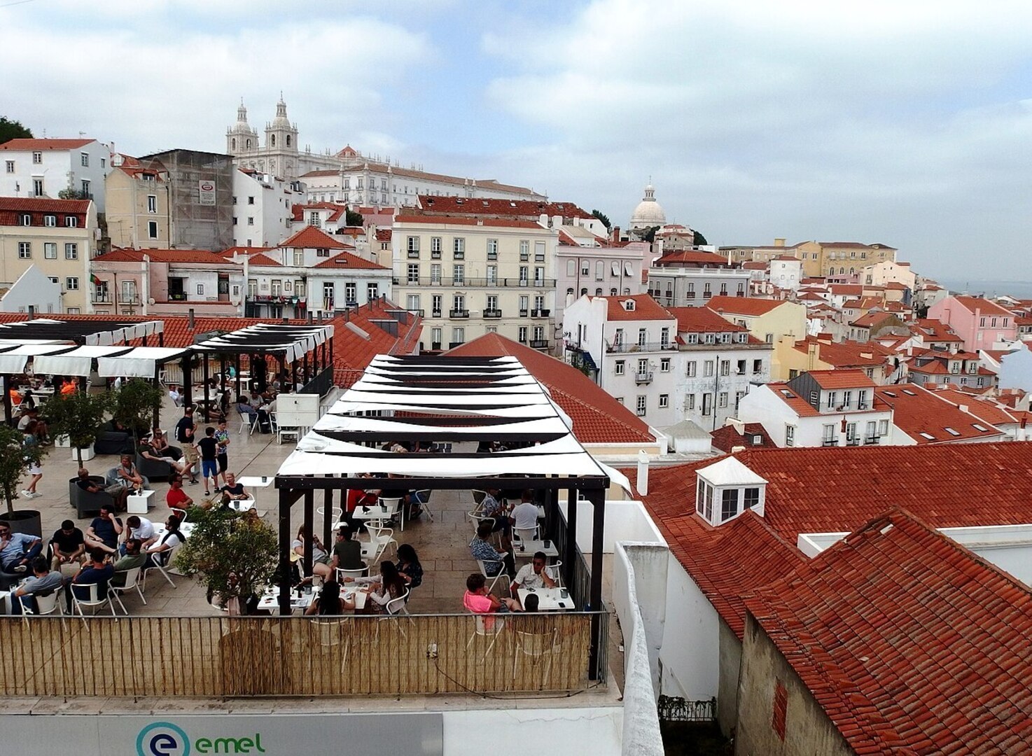 Golden afternoon light over Lisbon's terracotta rooftops and the Tagus River viewed from a miradouro in May