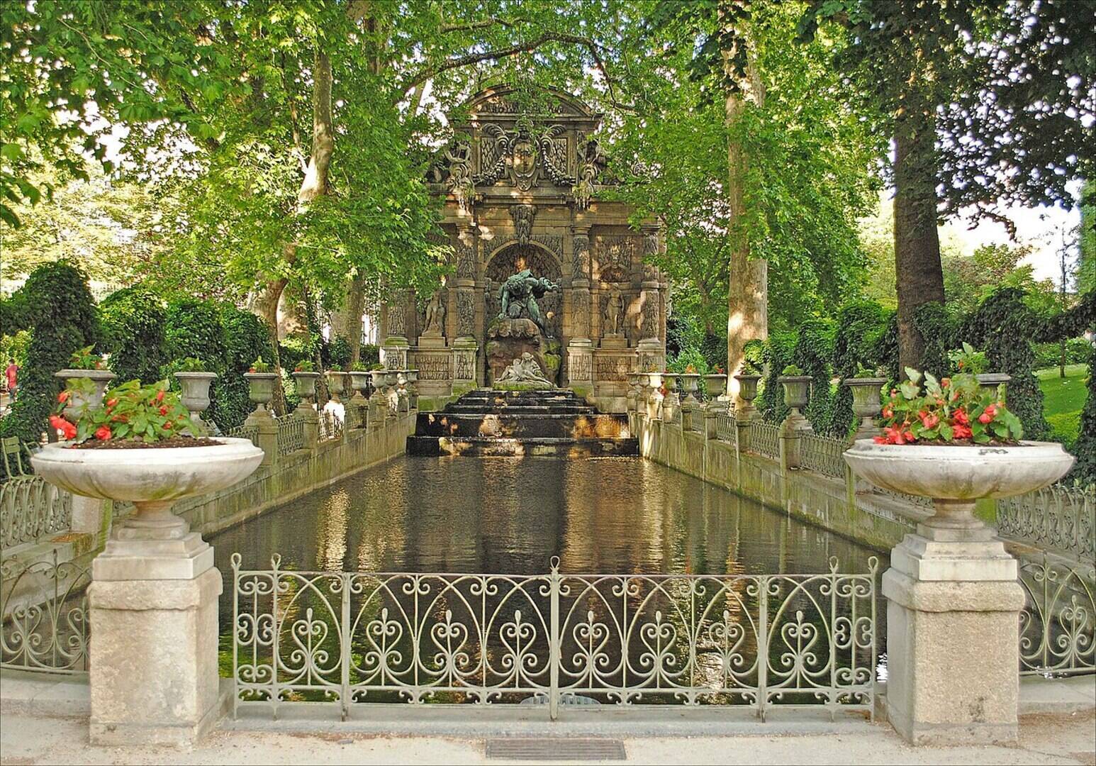 The Medici Fountain at Luxembourg Gardens with its long reflecting pool lined by plane trees in spring