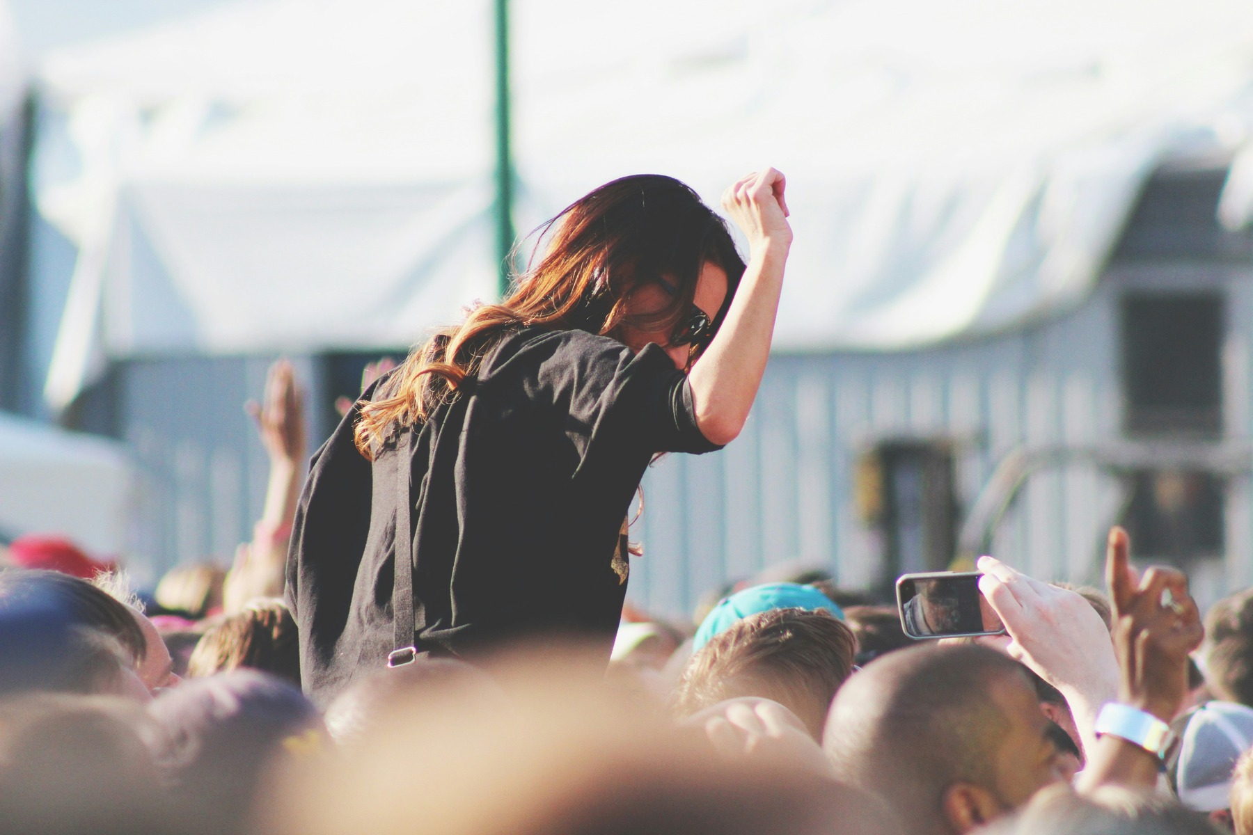 A lively festival crowd with raised hands during a daytime set at MEO Kalorama in Lisbon