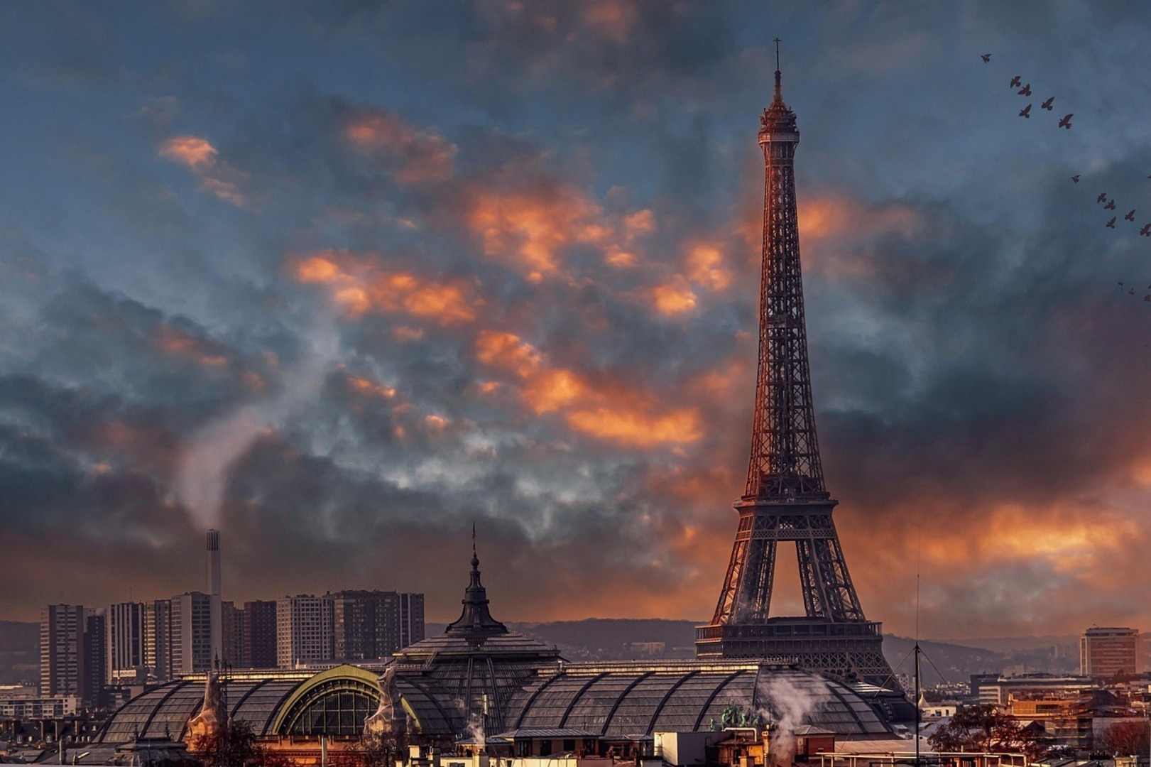 The Eiffel Tower at dusk in June with the summer sky still faintly illuminated behind it