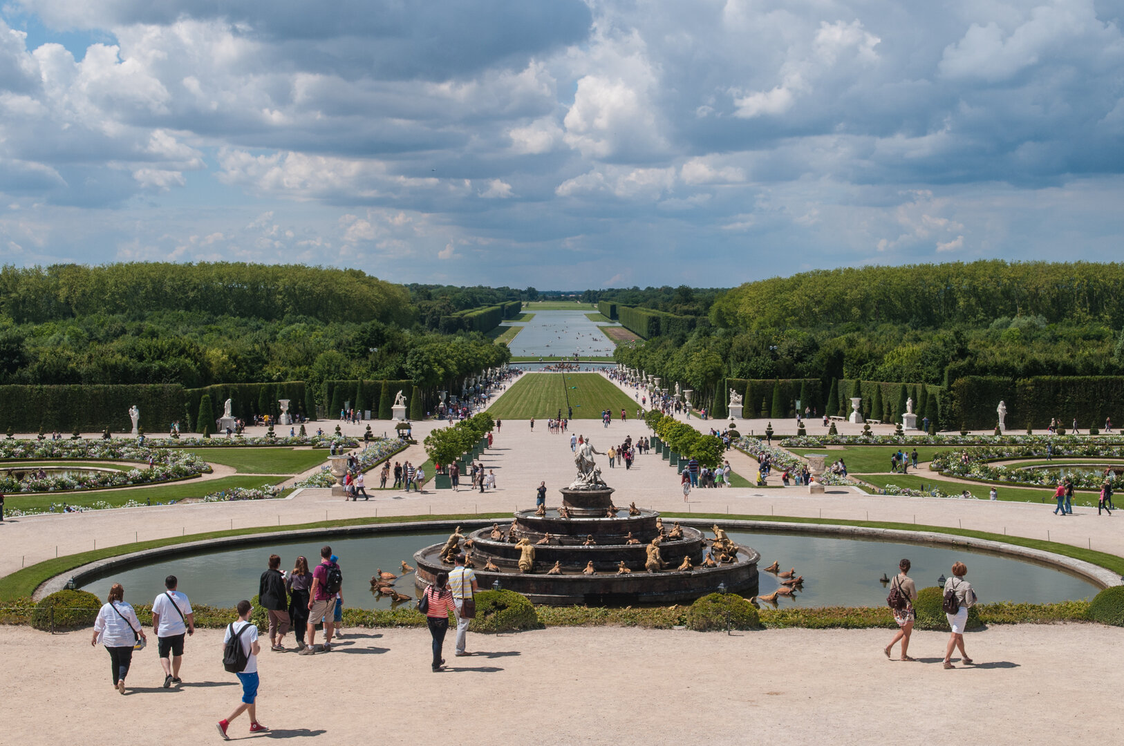 Visitors walking along the fountain in the Versailles gardens during spring