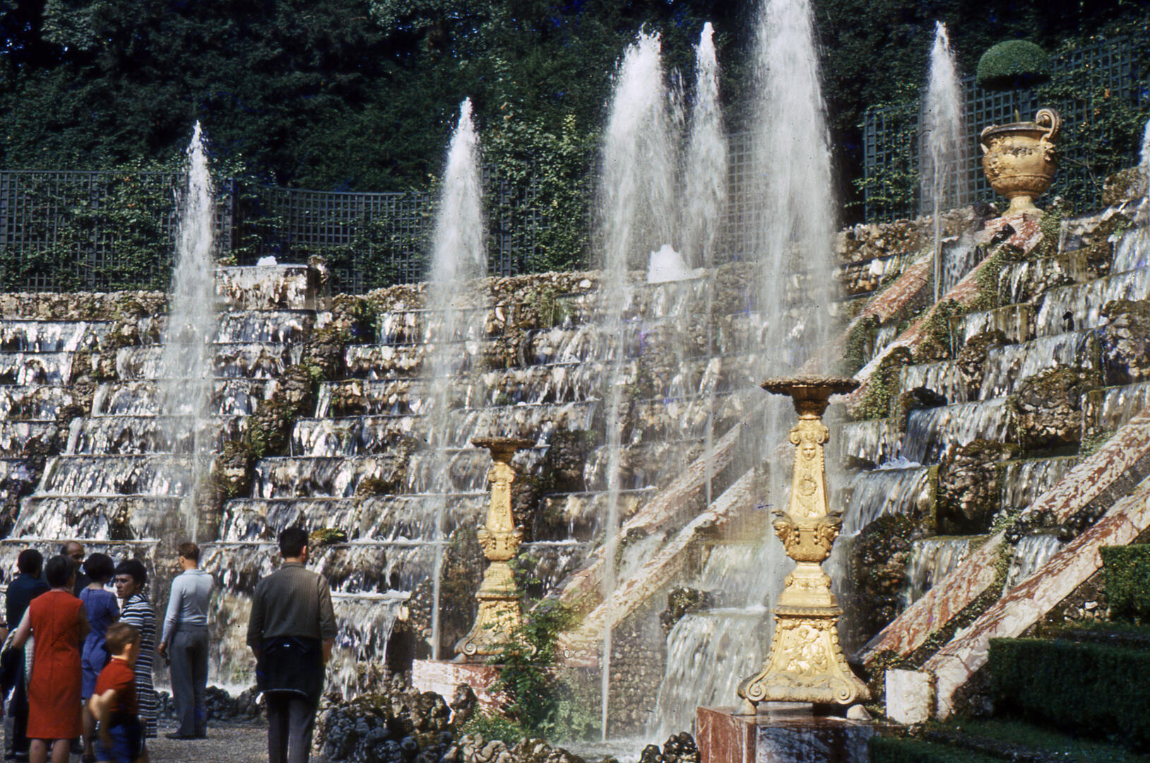 Visitors walking through a leafy Versailles grove during a fountain show day