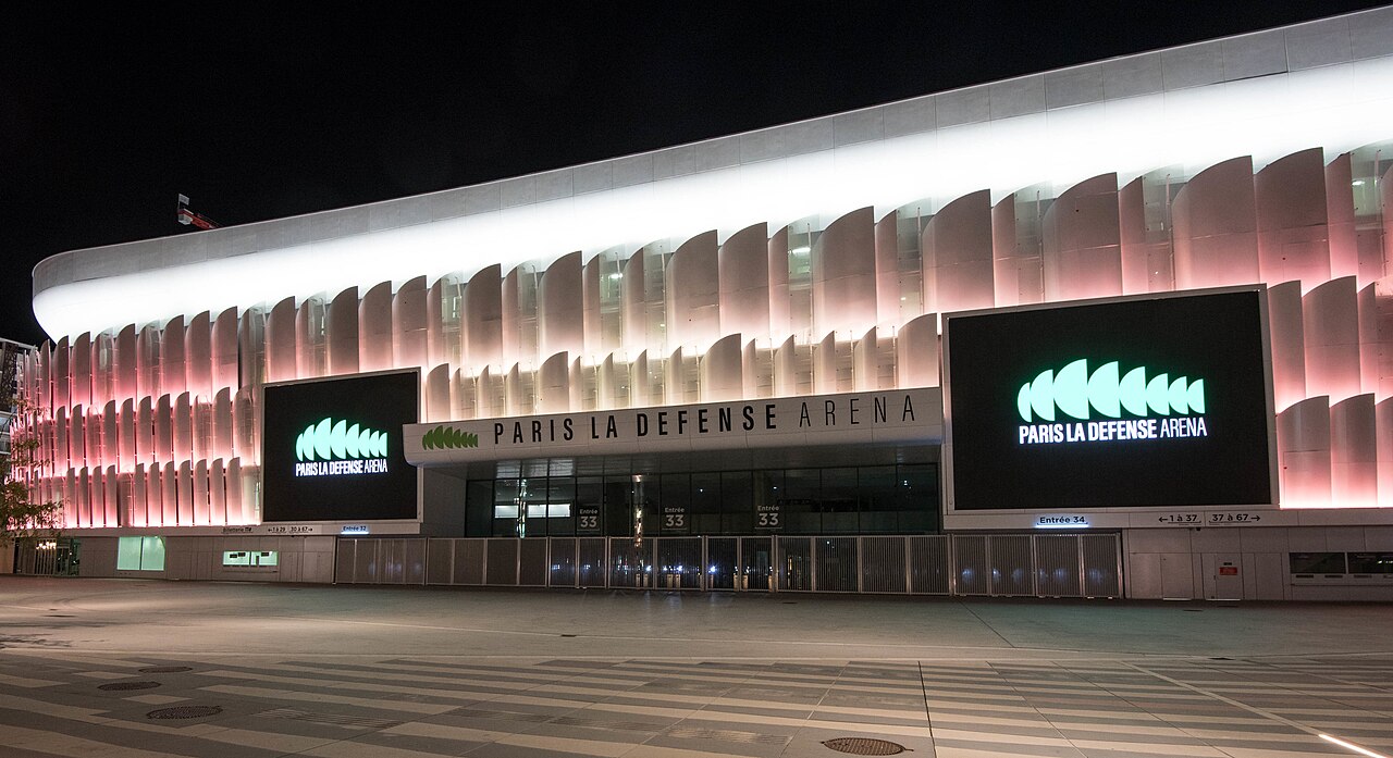 Paris La Défense Arena lit up at night, the venue for the Celine Dion Paris 2026 concert residency